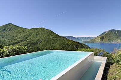 Infinitypool mit heller Poolfolie in den Bergen mit Seeblick